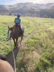 Caedyn on Rosie - out on the trail being "pony-ed" with/by another more seasoned trail horse.